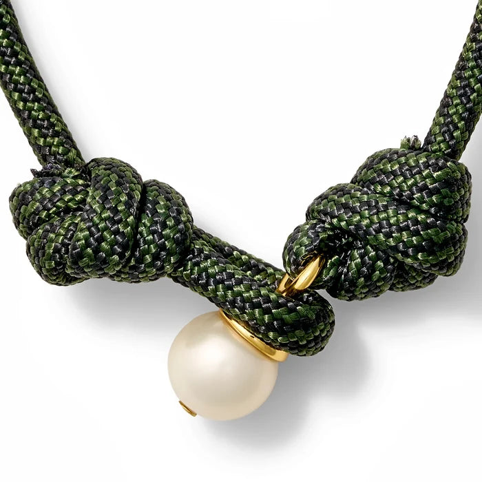 Hunter green and black bracelet with a pearl button closure on a white background